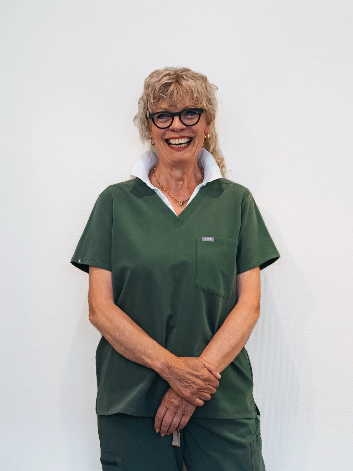Portret van tandartsassistente Claudia in groene werkkleding